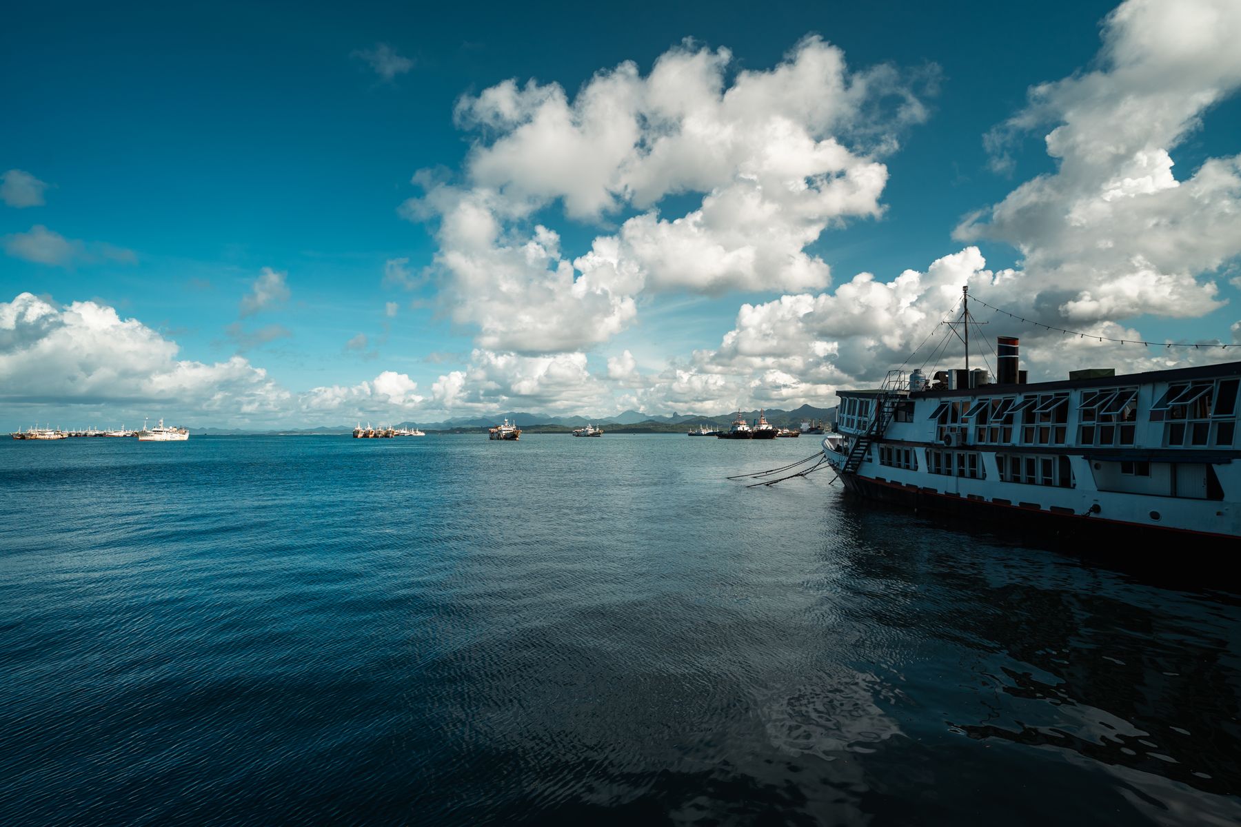 Clouds above Suva Harbour, with boats on the blue water.